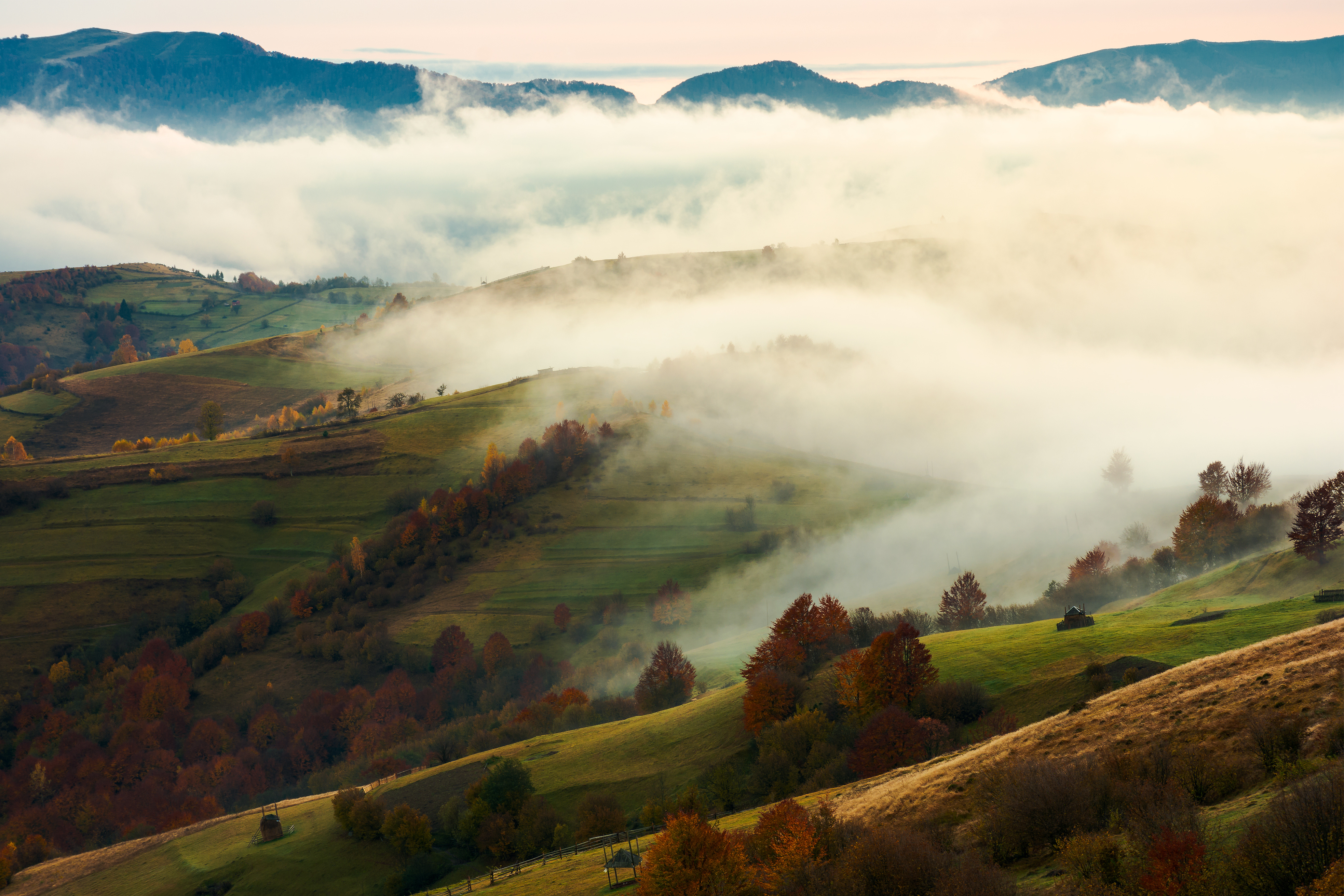 Tipps zum Heizen bei schwieriger Wetterlage Herbstliche Landschaft mit Nebel über Hügeln